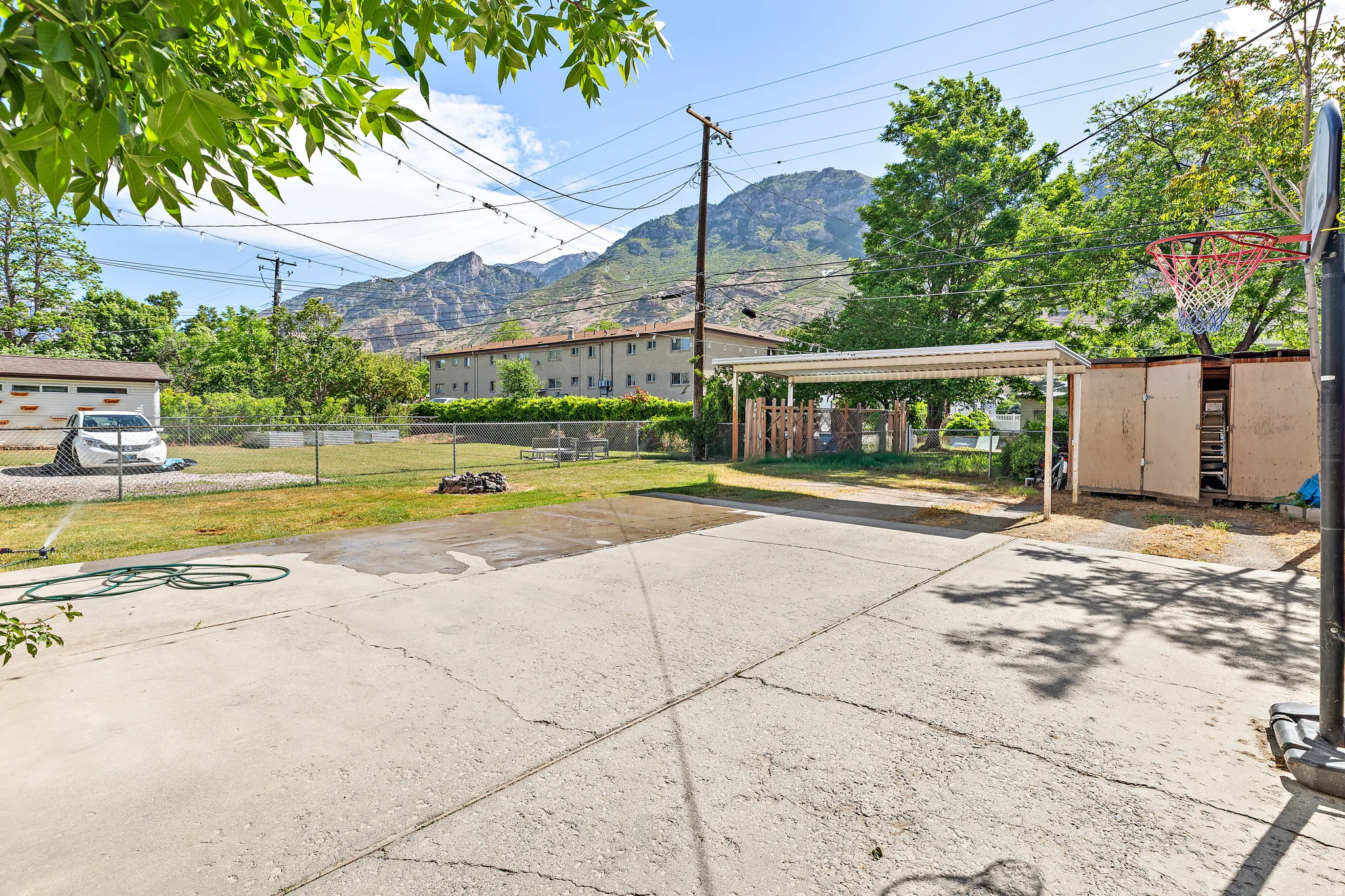 Concrete patio and yard area featuring a detached carport structure