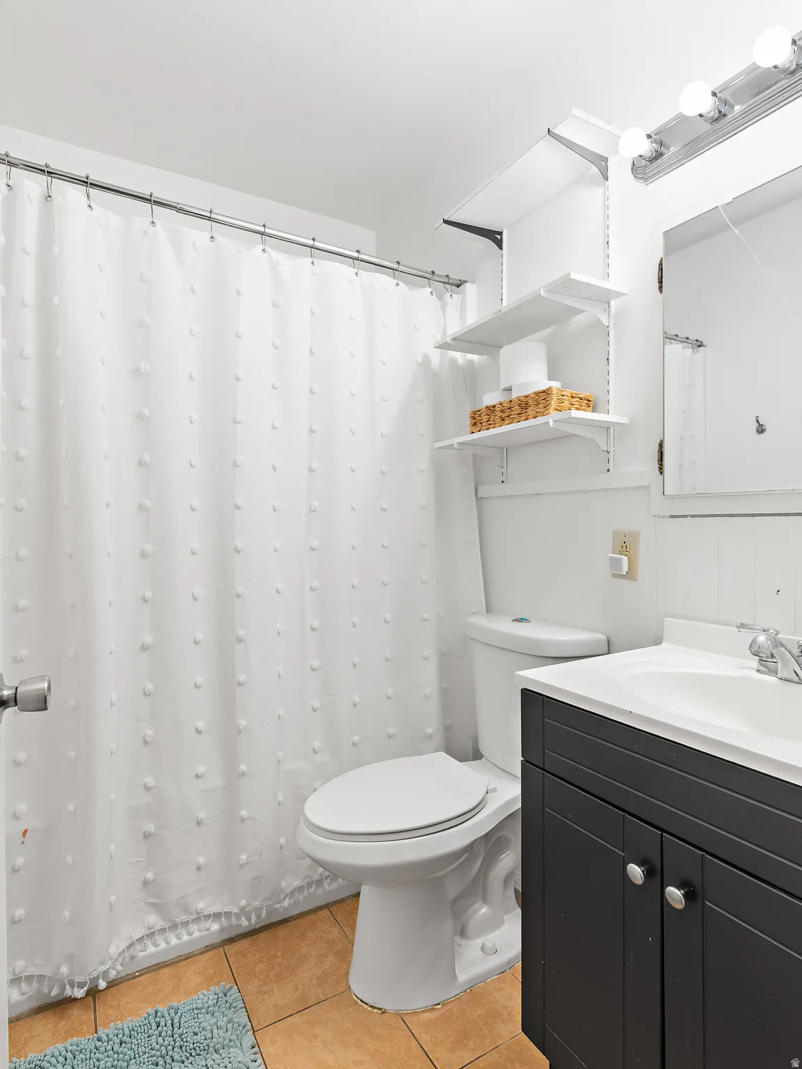 Bathroom featuring a vanity with dark cabinetry, white countertop, and integrated sink