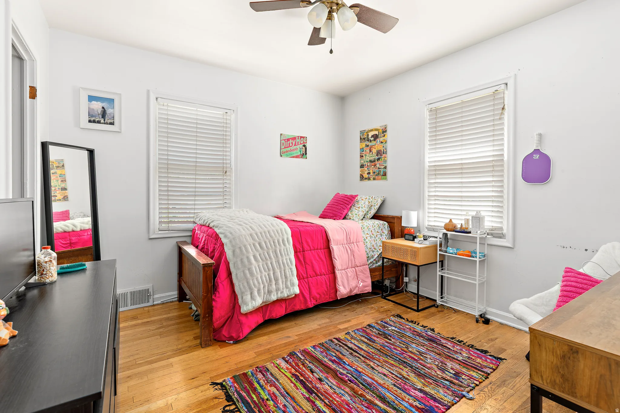 Hardwood flooring features throughout this room, complemented by a ceiling fan with integrated lighting