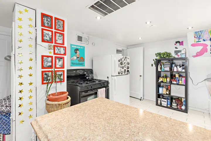 Kitchen featuring a full-size range, white appliances, recessed lighting, and tile flooring
