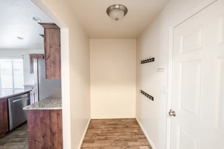 Wood-finish flooring, recessed lighting, white paneled door, and a flush mount ceiling light