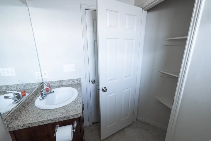 Vanity with an integrated sink, polished chrome faucet, and stone-look countertop