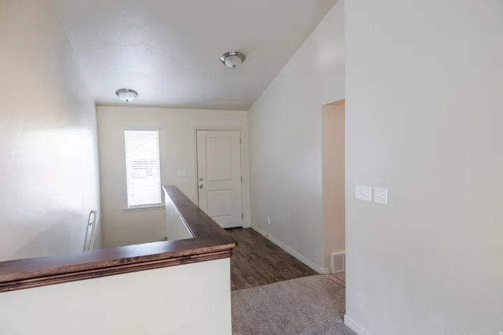 Entryway featuring wood-finish flooring, a white paneled door, and a window with blinds