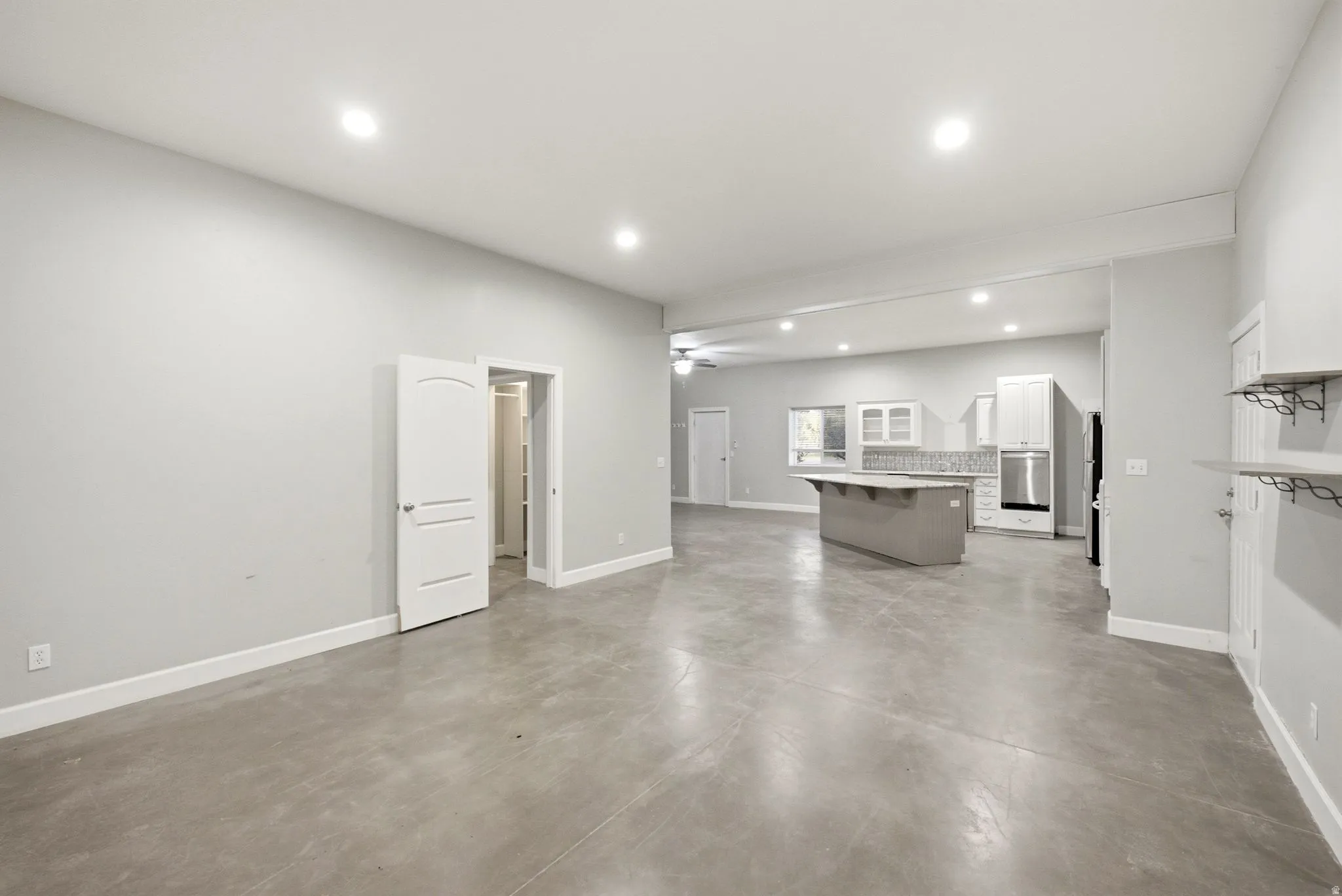 Apartment in the shop. Expansive open-concept room featuring concrete flooring, recessed lighting, and a neutral color palette