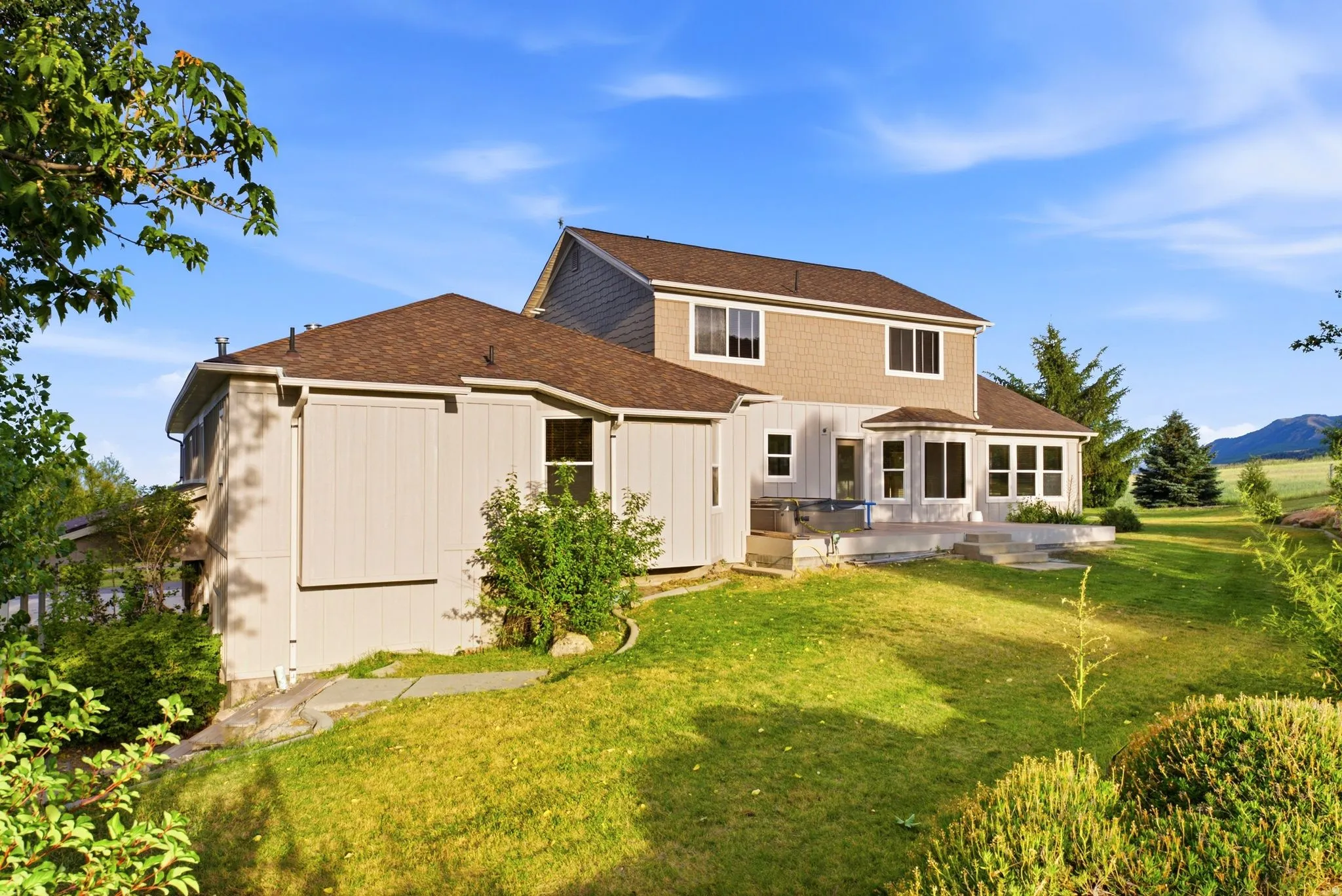 Two-story property featuring a multi-level deck, bay window, and varied exterior siding