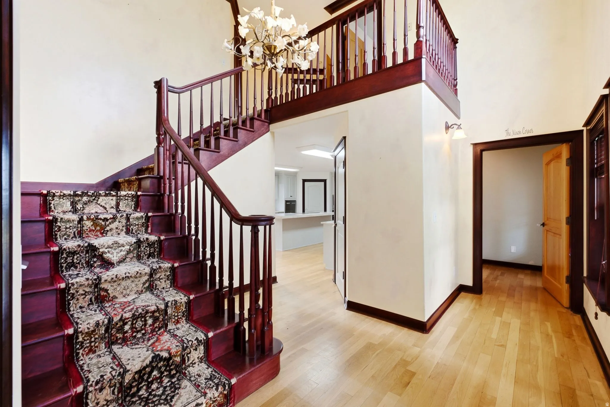 Grand entry featuring a dark wood staircase with ornate carpet runner