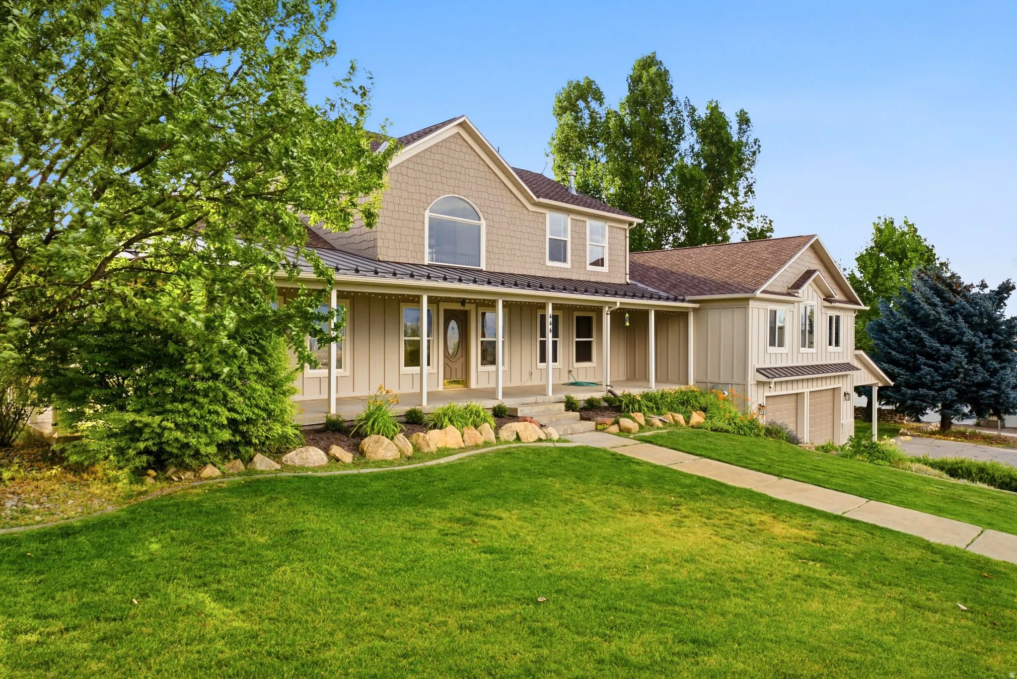 Two-story residence featuring a covered front porch, a gabled roofline with architectural shingles, and an attached two-car garage