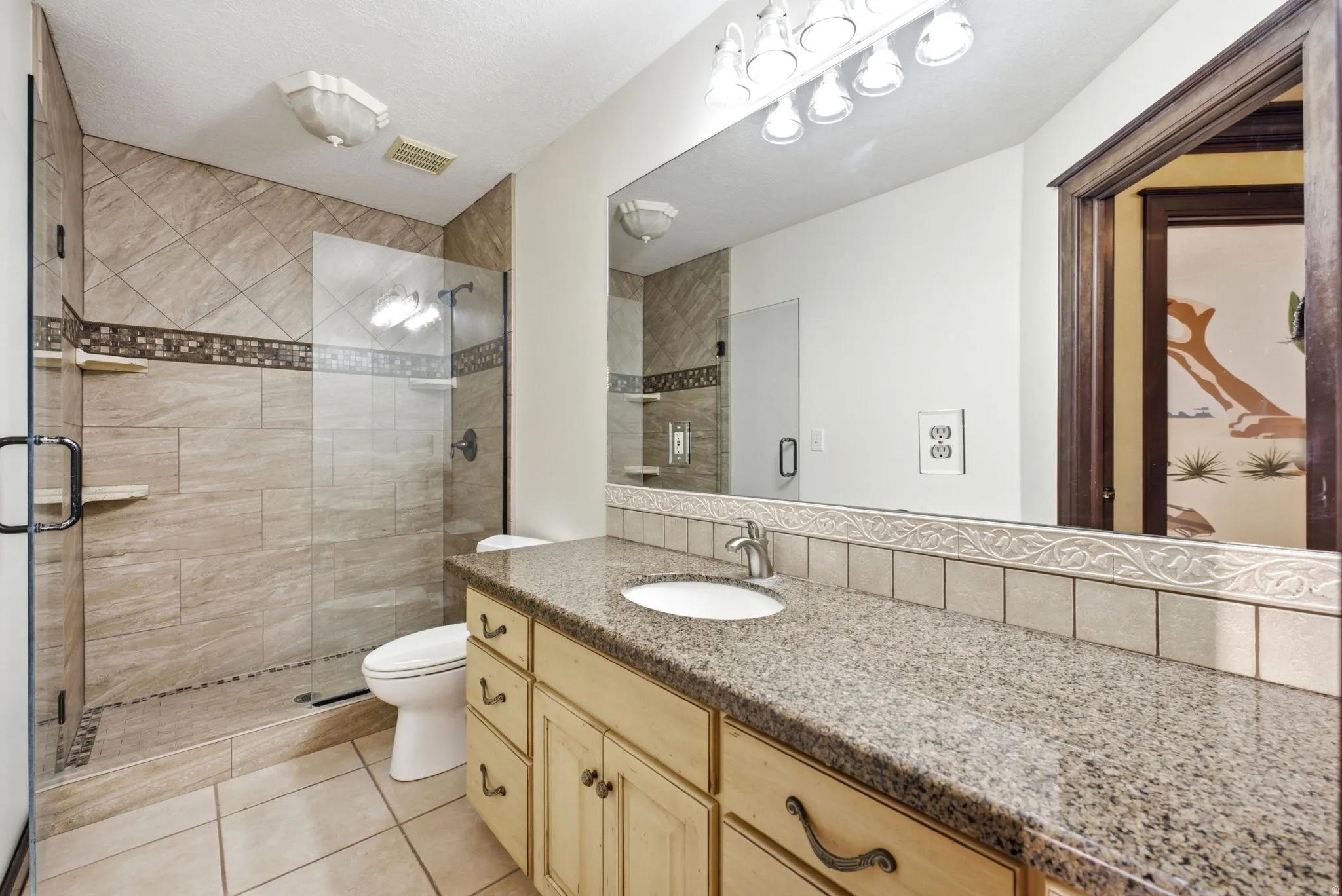 Upstairs bathroom featuring a granite-look countertop, undermount sink, and light-toned wood cabinetry
