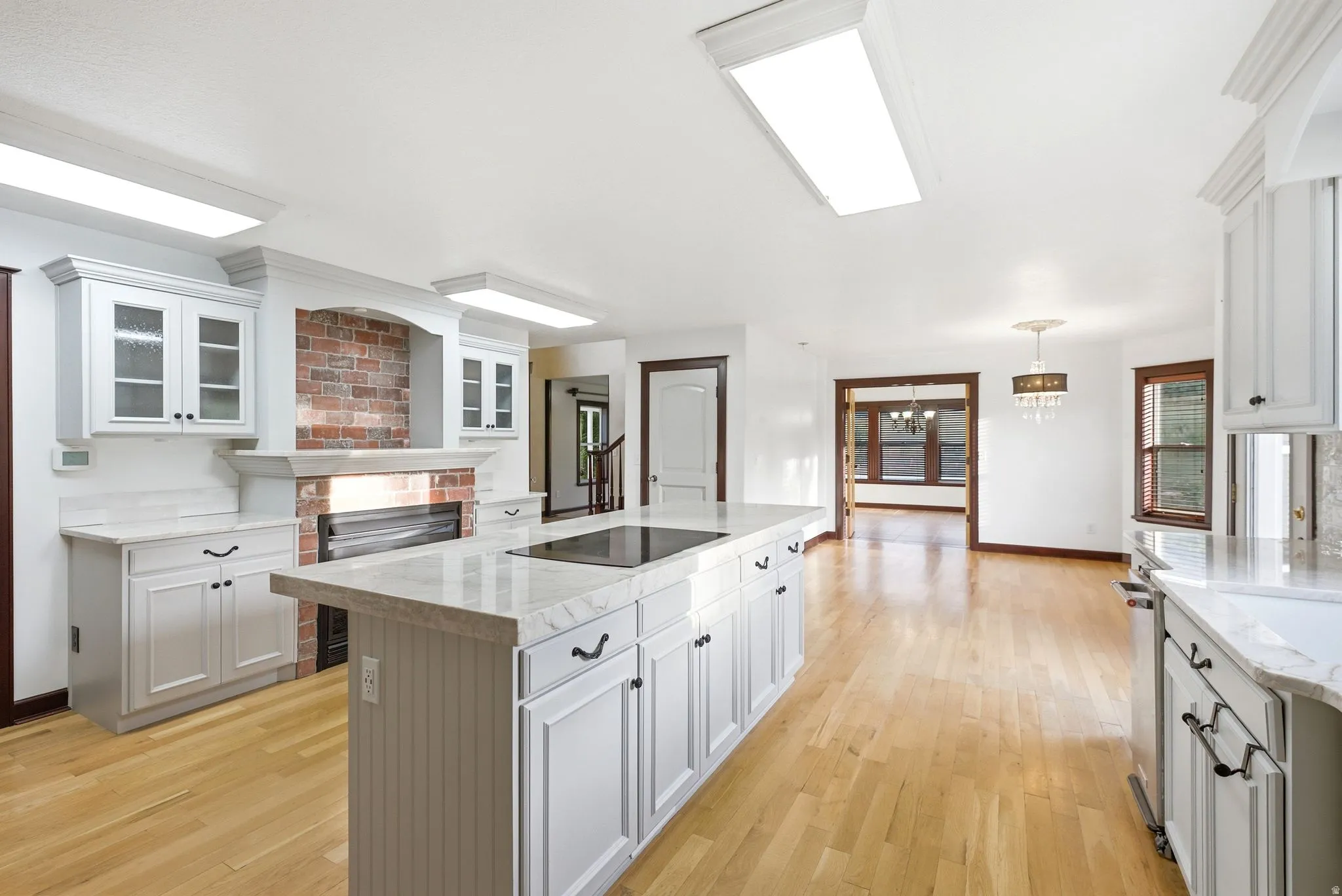 Open-concept kitchen and living area featuring light wood-finish flooring