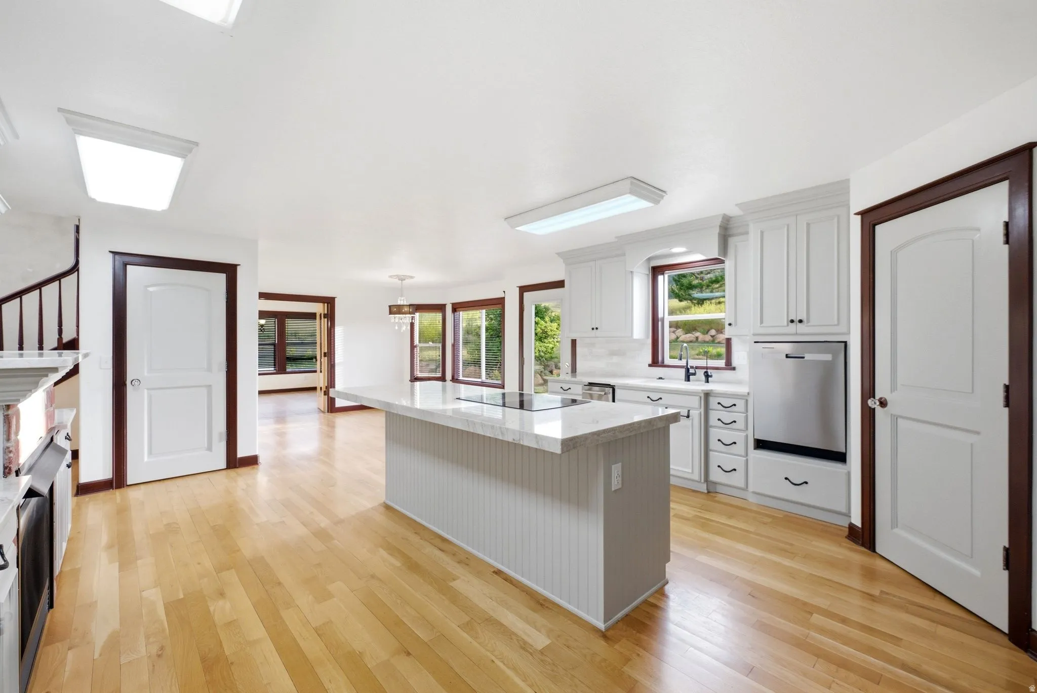 Kitchen featuring a central island with a built-in cooktop and beadboard base