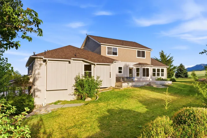 Two-story property featuring a multi-level deck, bay window, and varied exterior siding