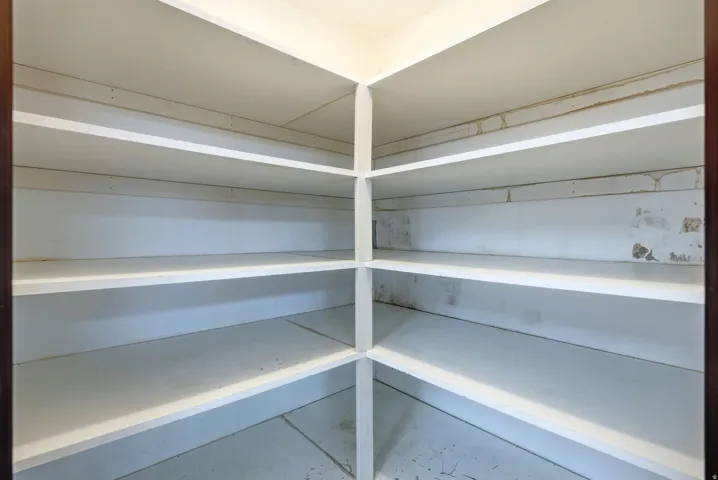 1st kitchen pantry with corner shelving unit with multiple white storage shelves