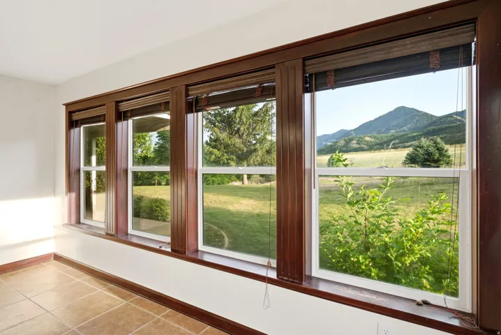 Formal dinning room. Expansive window wall with rich wood trim, offering broad outdoor scenery