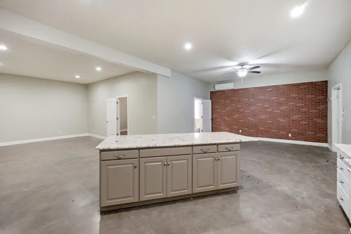 Kitchen island featuring a light-colored countertop and cabinetry with brushed nickel hardware
