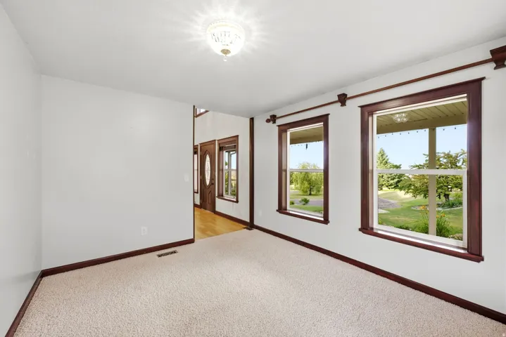 Formal living room. Carpeted interior space with white walls and dark wood trim