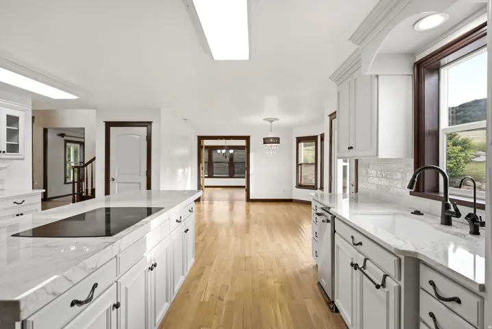 Kitchen featuring white shaker cabinetry, light-toned wood-finish flooring, and white countertops