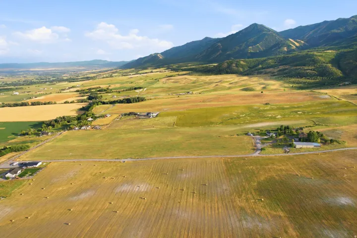 Expansive agricultural landscape featuring various fields and distant mountain ranges