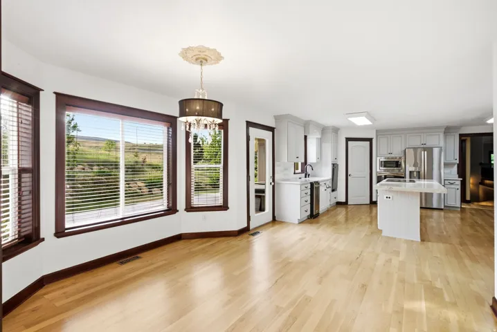 Open-concept living space featuring wood-finish flooring and white walls