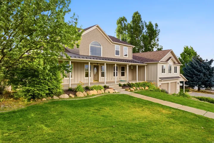 Two-story residence featuring a covered front porch, a gabled roofline with architectural shingles, and an attached two-car garage