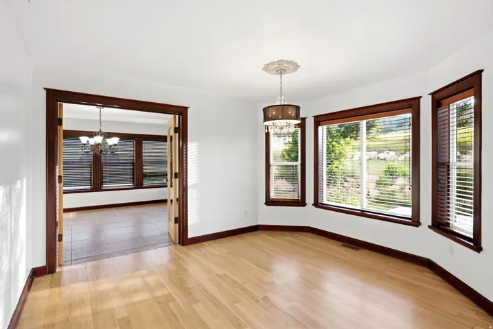 Light wood-finish flooring with white walls and dark wood trim
