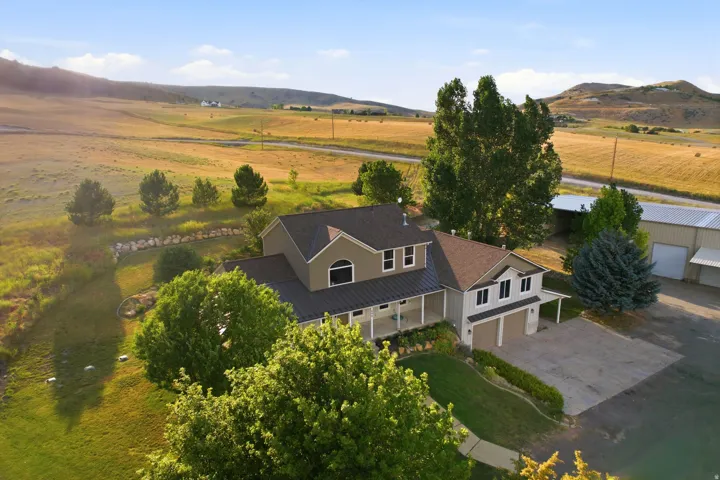 Two-story residence featuring a two-car garage, covered front porch, and a metal roof