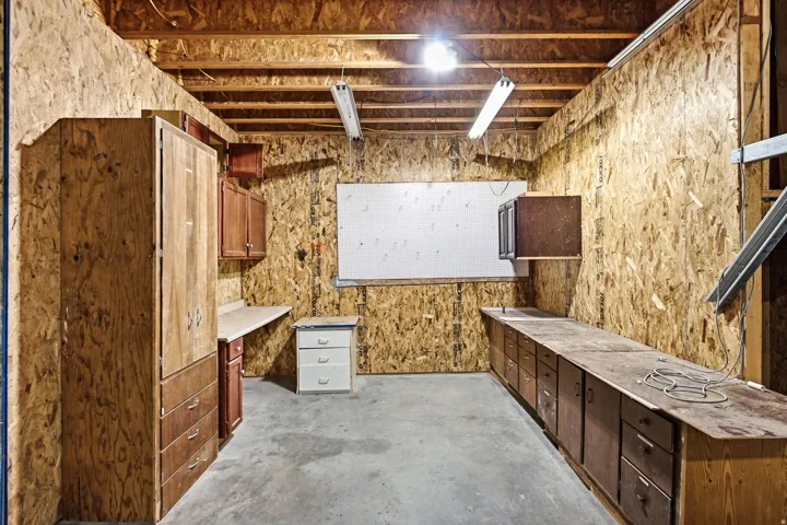 Utility room featuring wood-finish cabinetry, ample countertop space, and overhead fluorescent lighting