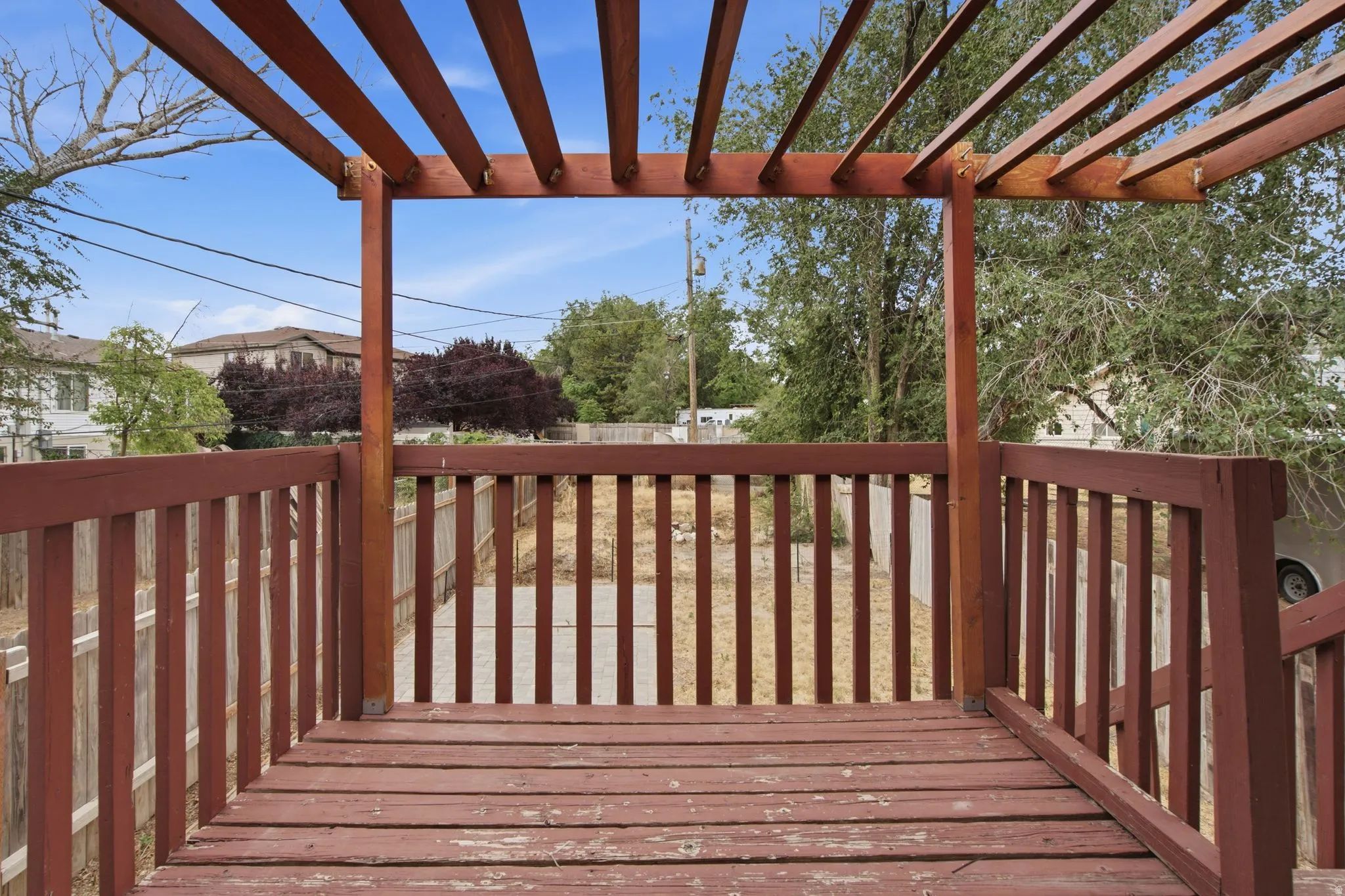 Wood-finish deck featuring a slatted pergola structure