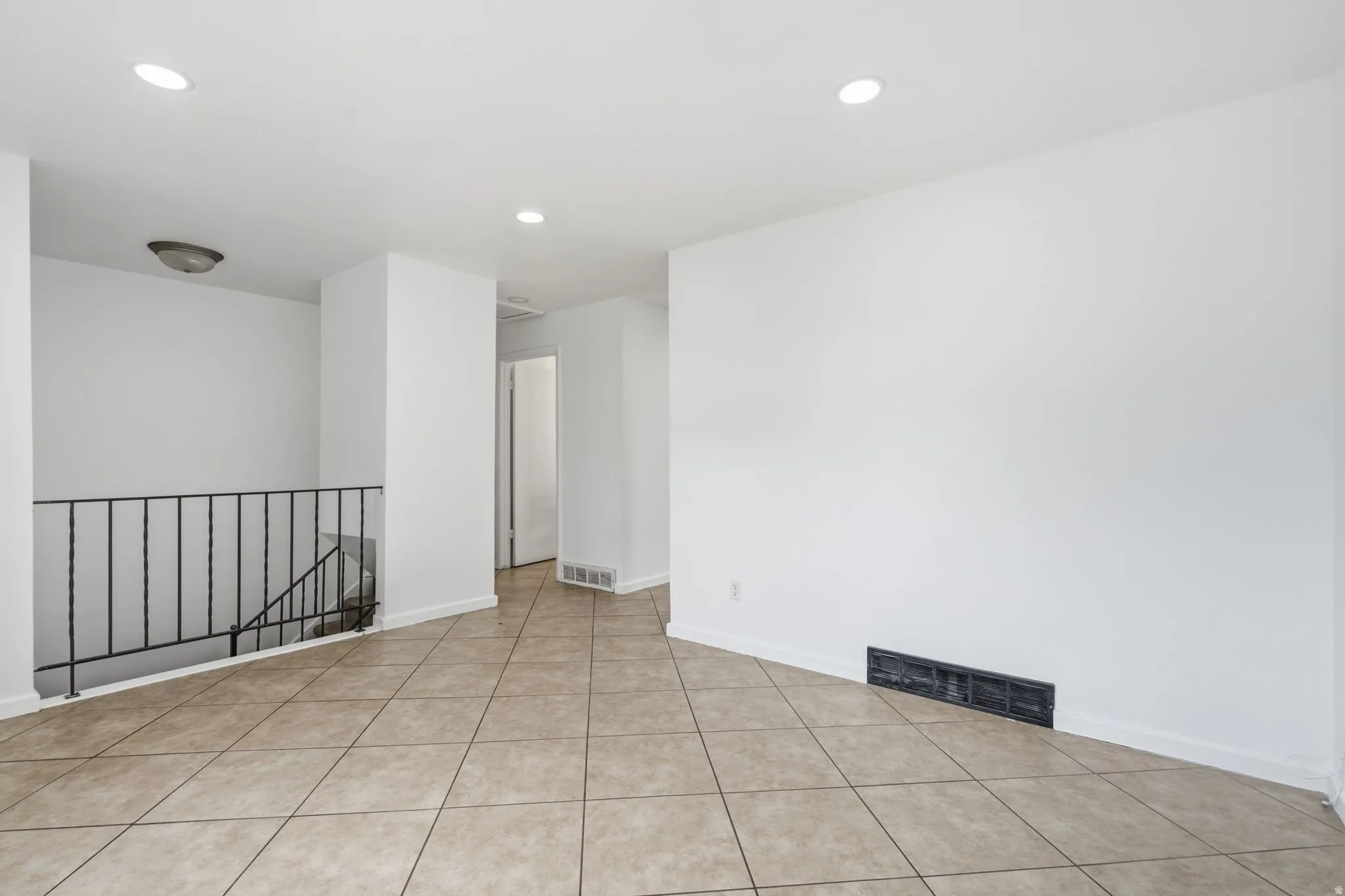 Tiled flooring with a neutral color palette, complemented by white walls and recessed lighting