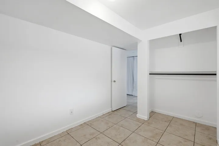 Neutral wall tones, recessed lighting, and tile flooring