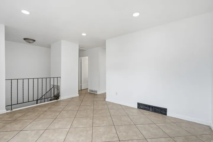 Tiled flooring with a neutral color palette, complemented by white walls and recessed lighting