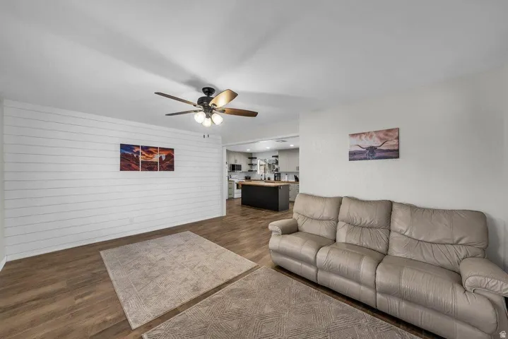 Spacious living area featuring wood-finish flooring and a white shiplap accent wall