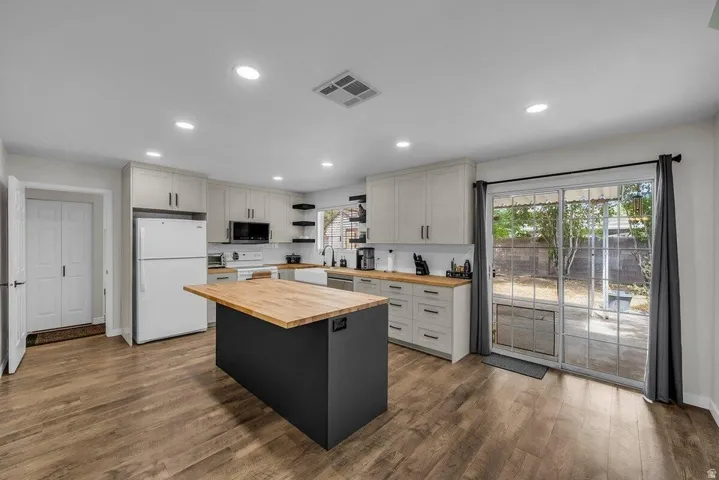 Kitchen featuring wood-finish flooring, recessed lighting, and light-toned cabinetry