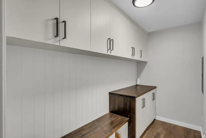 Built-in cabinetry with matte black hardware, wood-finish flooring, and shiplap wall accents