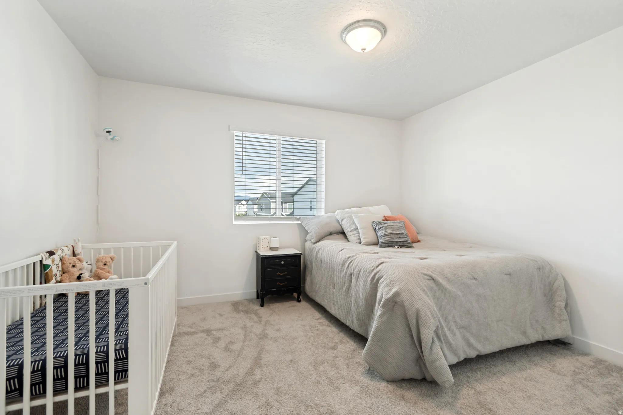 Carpeted room featuring a single window with blinds, a flush-mount ceiling light, and white walls