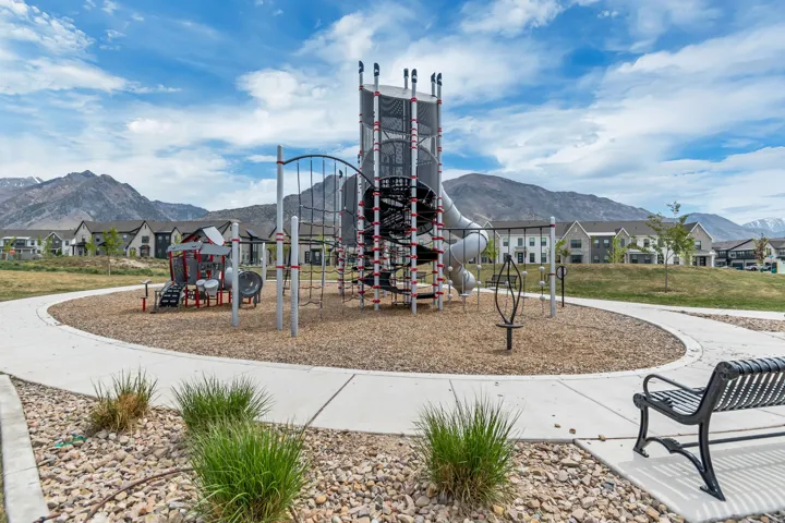 Community playground featuring a multi-level play structure with slides and climbing elements
