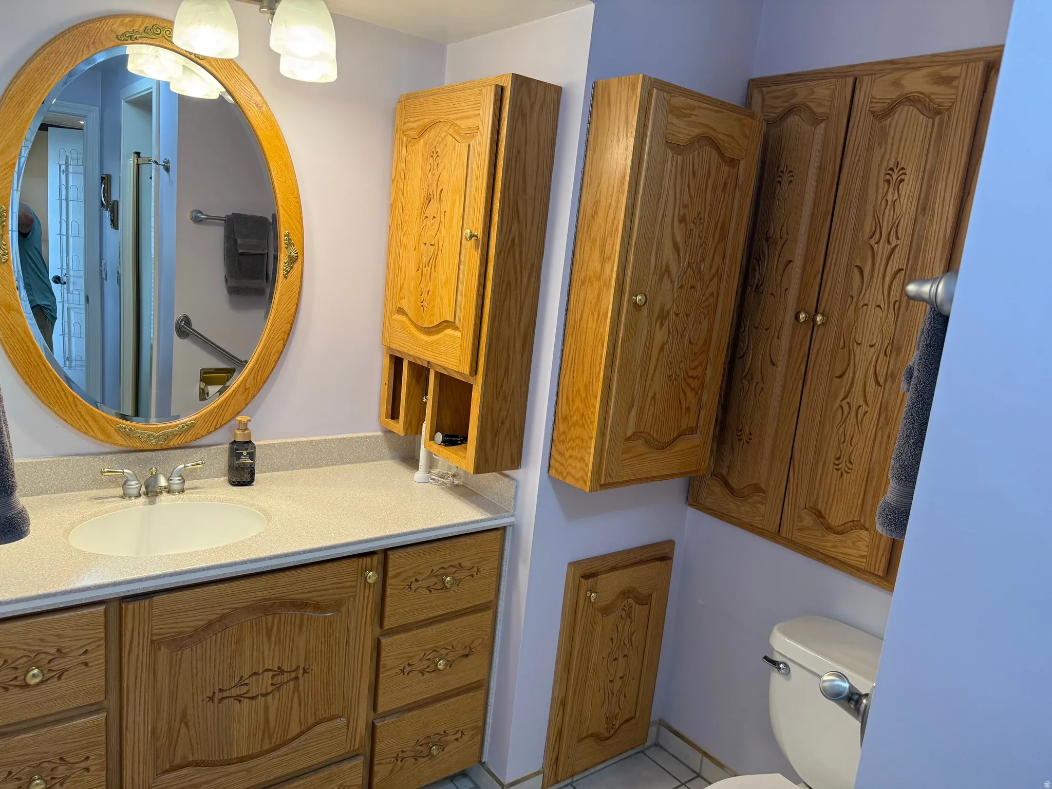 Bathroom featuring a custom wood-finish vanity with an integrated sink and laminate countertop