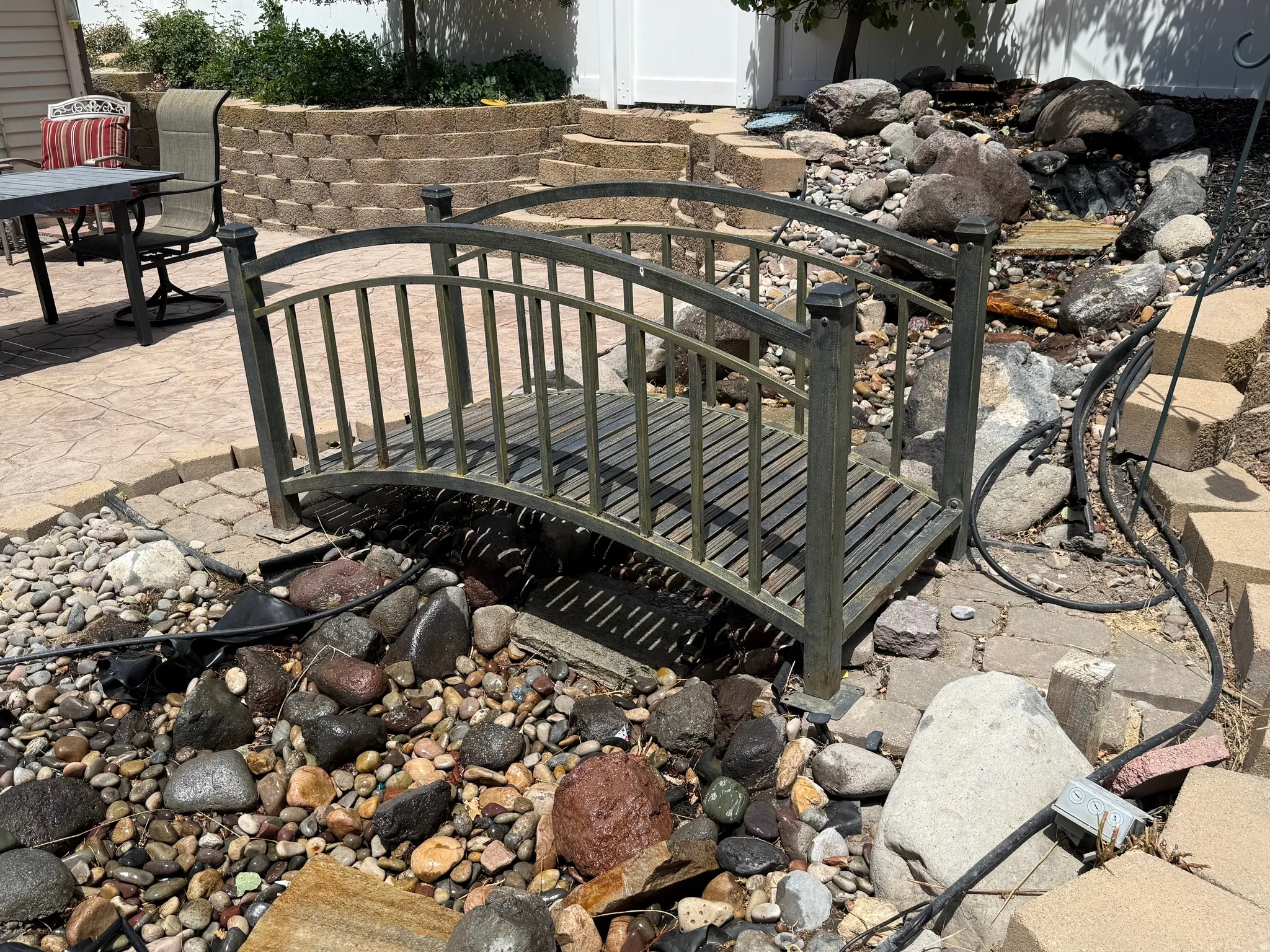 Decorative footbridge spanning a rock-lined water feature