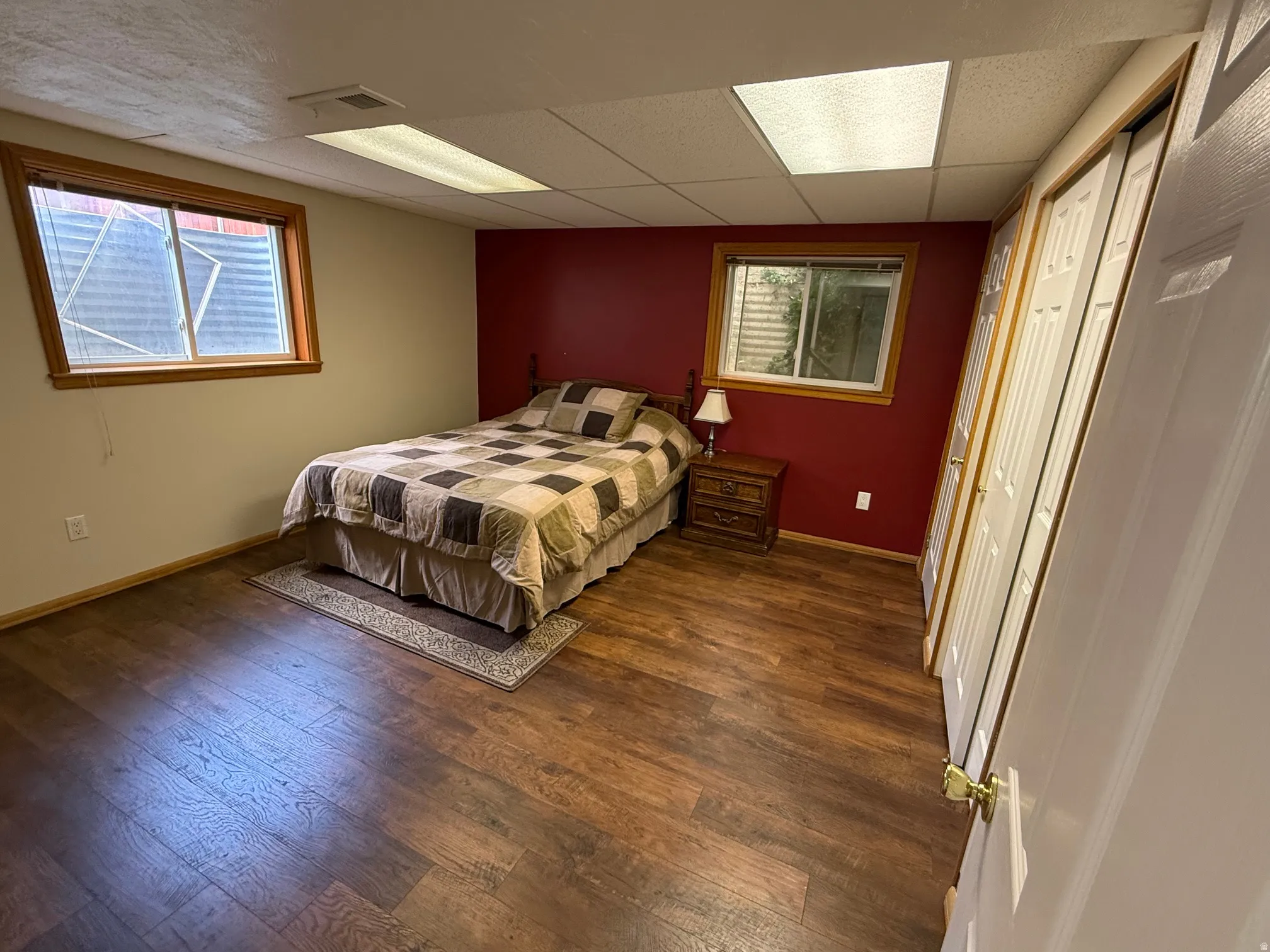 Interior room featuring wood-finish flooring and a window with wood trim