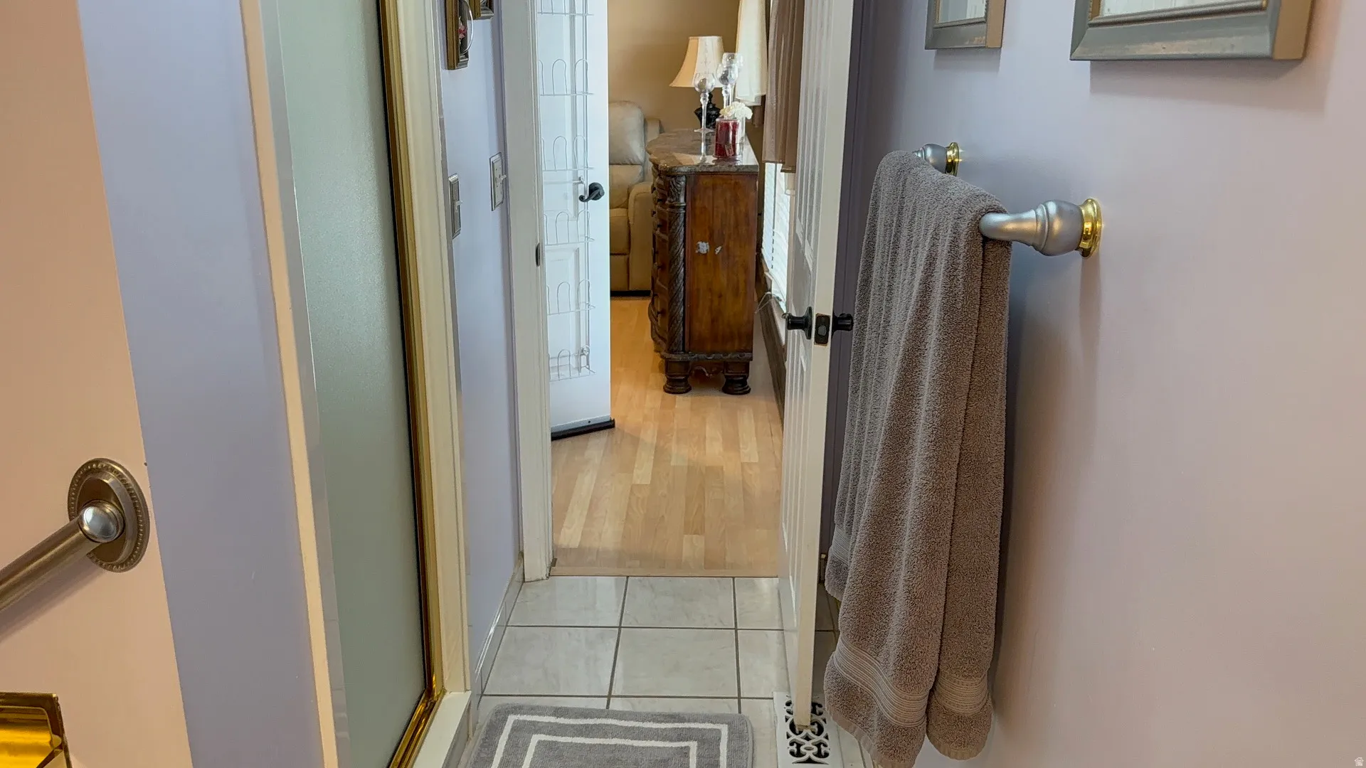 Bathroom featuring light lavender walls, tiled flooring, and a shower enclosure