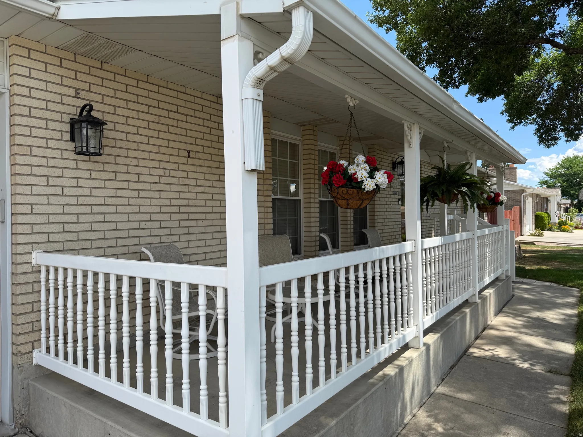 Covered front porch featuring white railings and columns