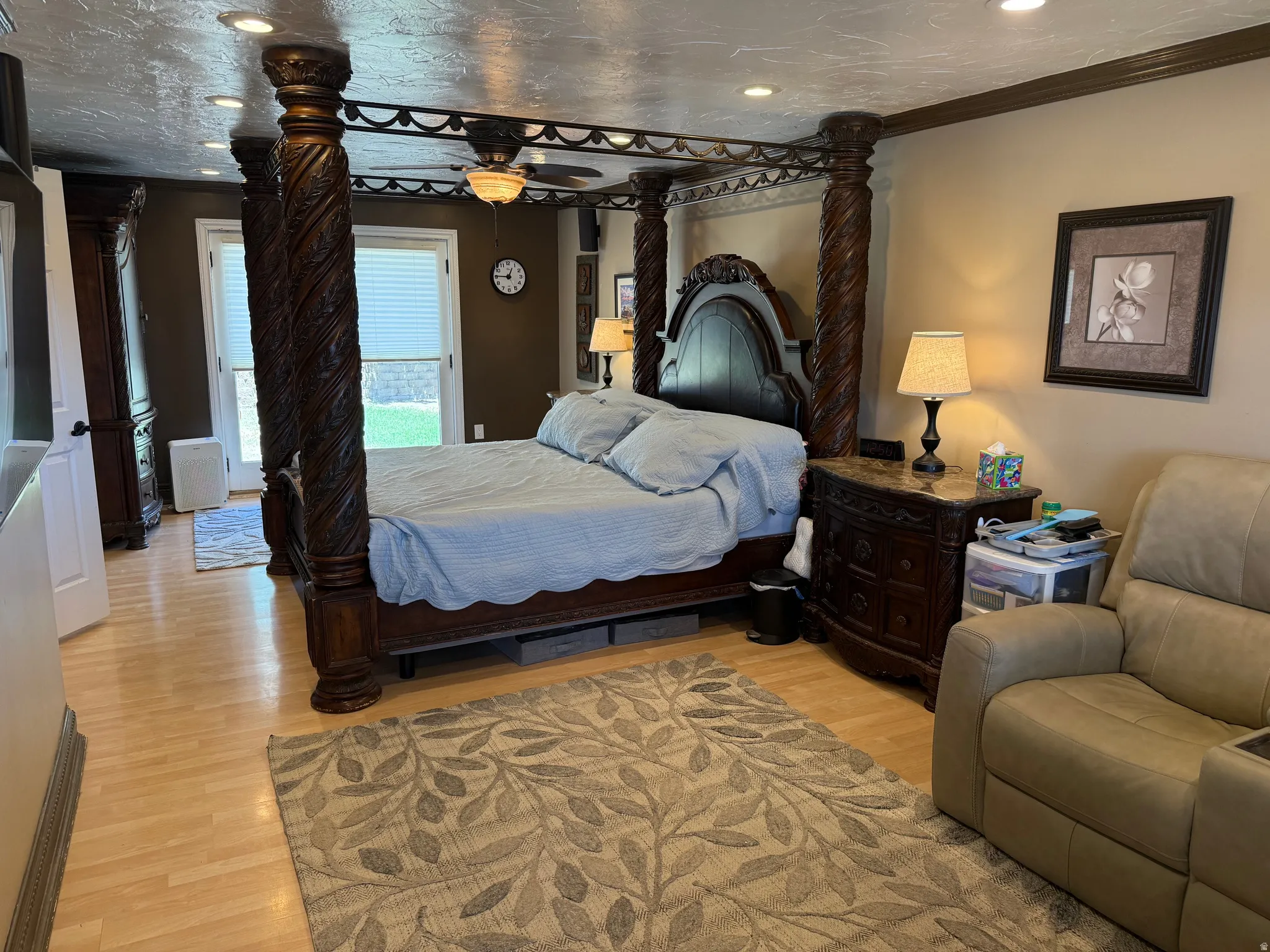 Large master bedroom. Light wood-finish flooring throughout, complemented by a ceiling fan with integrated lighting