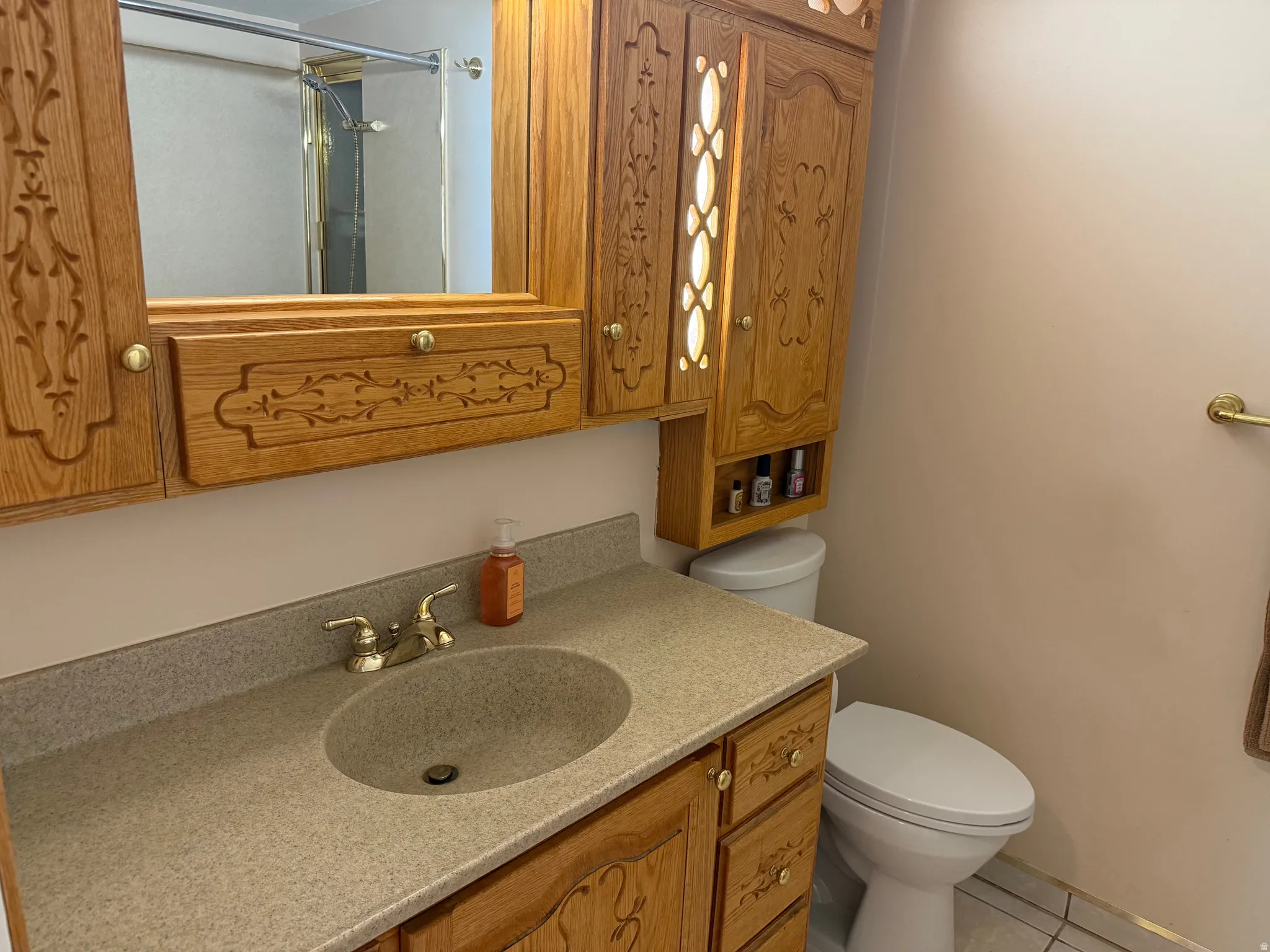 Bathroom vanity featuring a built-in sink and brass-finish faucet. Custom cabinetry.