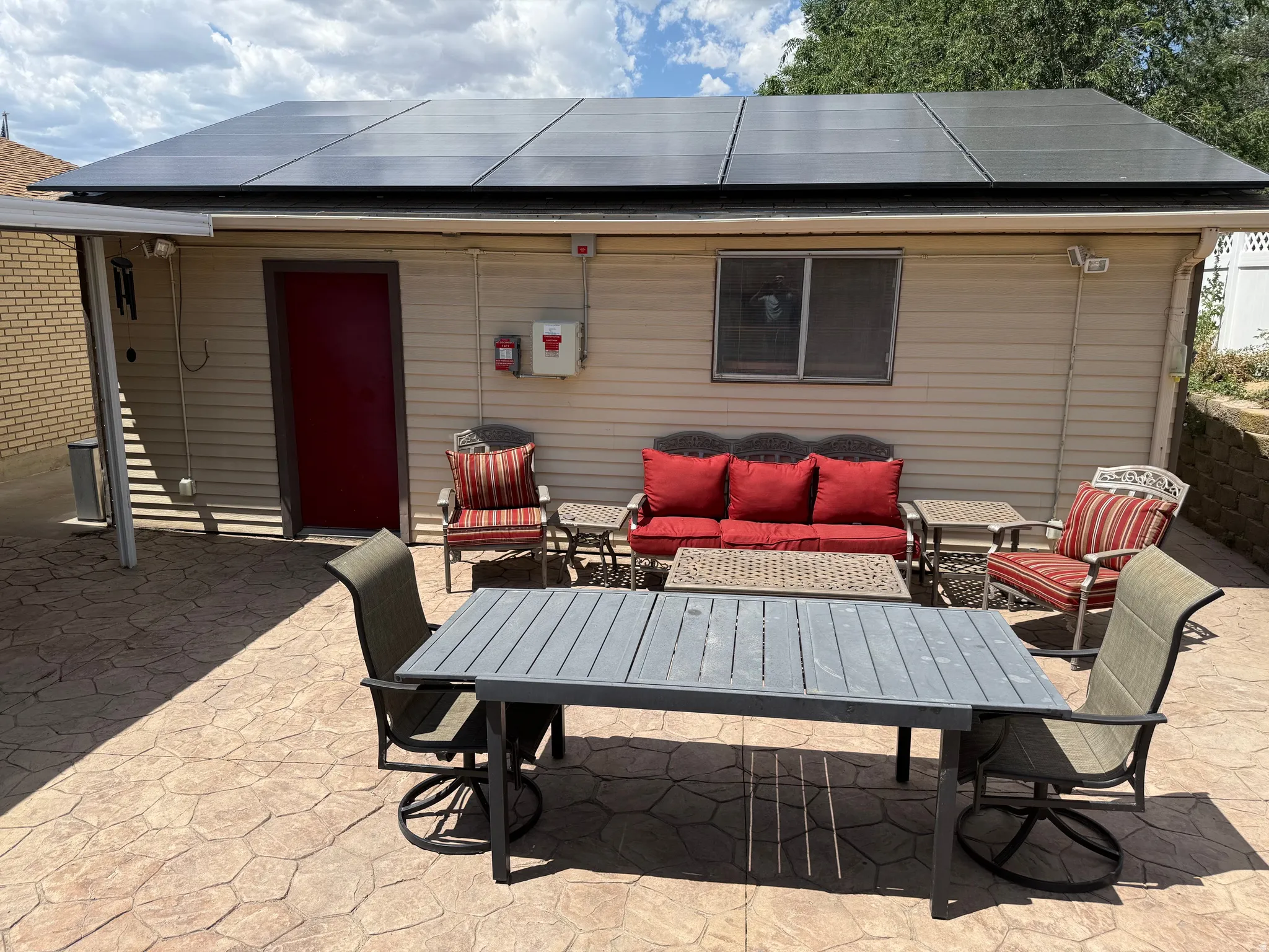 Rear workshop building with roof-mounted solar panels, beige siding