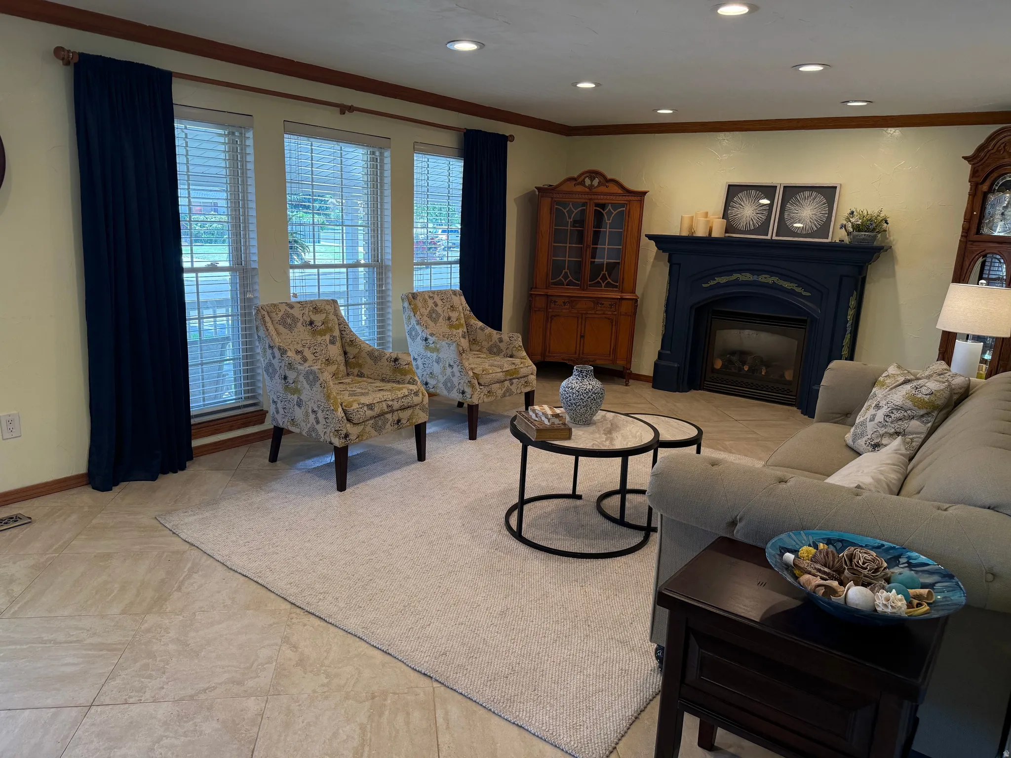 Living area featuring multiple windows with blinds, recessed lighting, tile flooring, and a gas fireplace with a decorative mantel