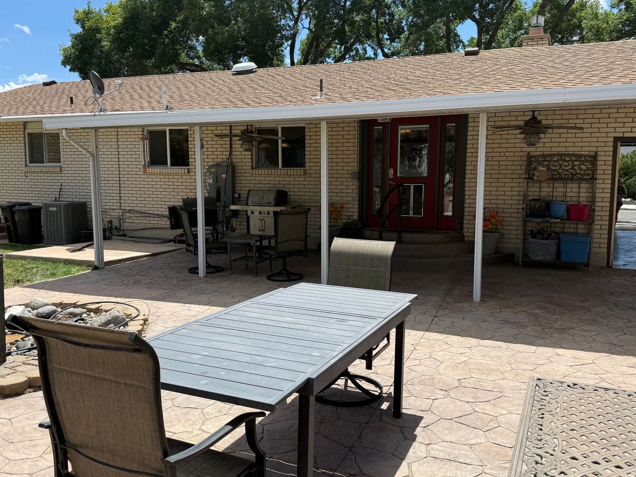 Brick exterior with a covered patio area and stamped concrete surface
