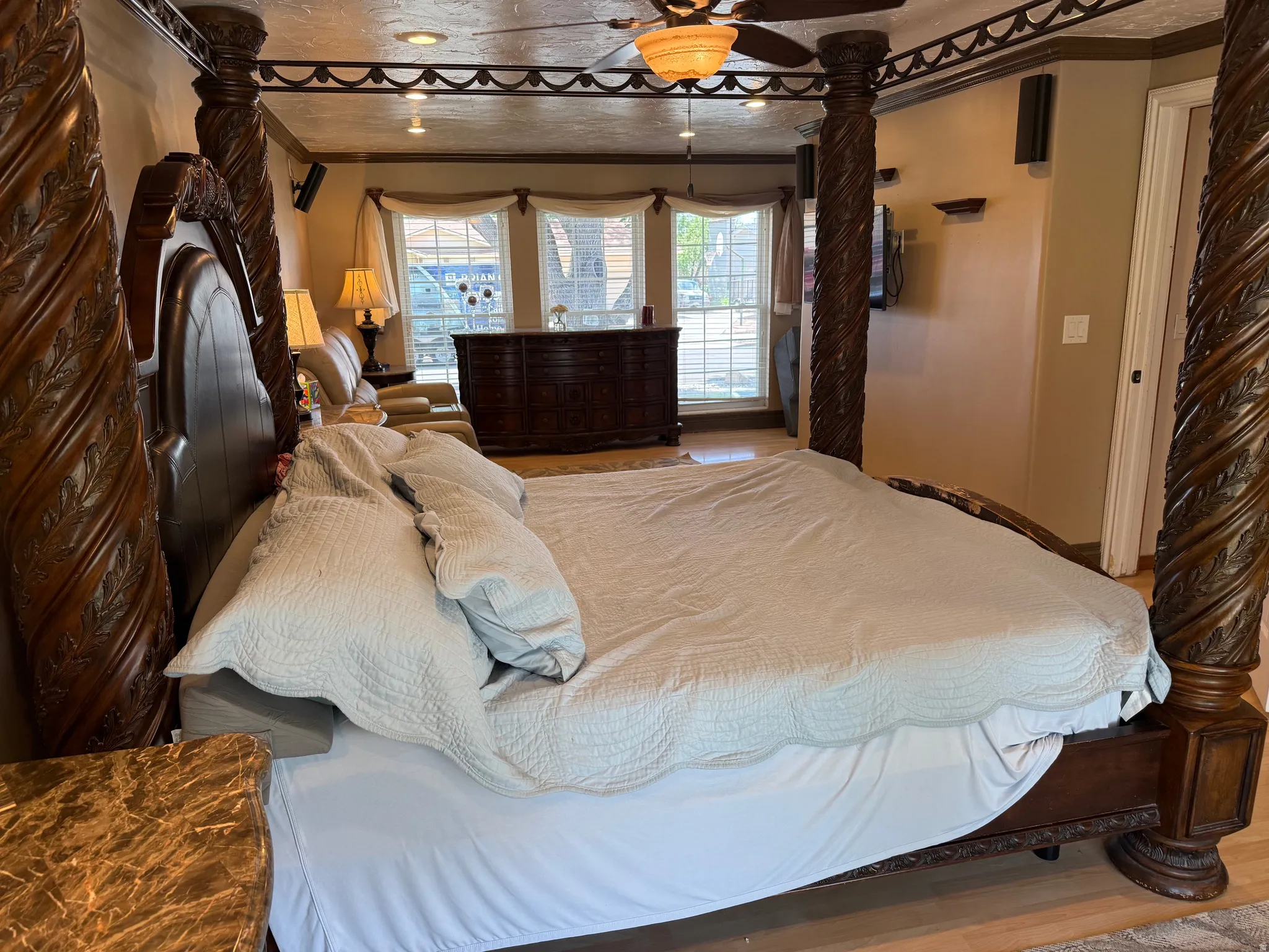Spacious master bedroom featuring wood-finish flooring, recessed lighting, and a ceiling fan