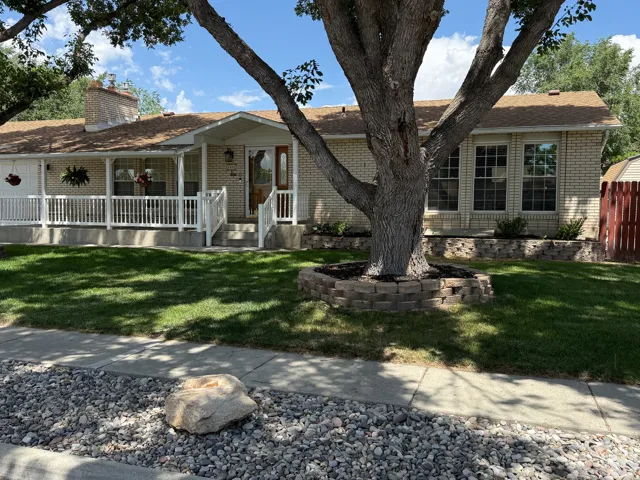 South facing home with brick exterior and a covered front porch and white railings