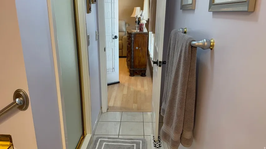 Bathroom featuring light lavender walls, tiled flooring, and a shower enclosure