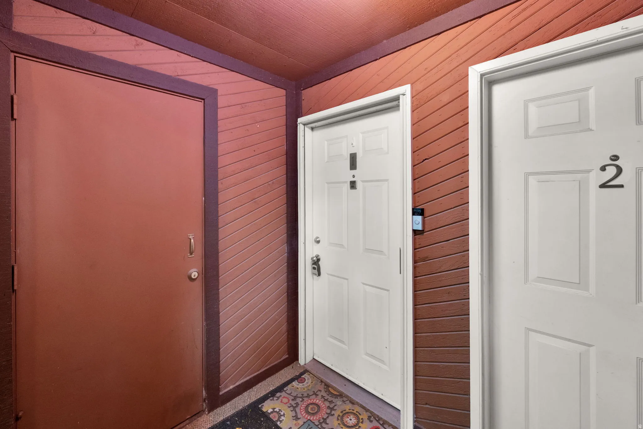 Entrance with a durable brown door and two white paneled doors