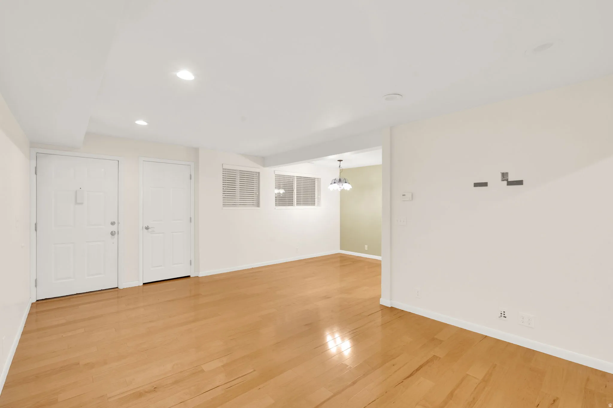 Spacious interior featuring wood-finish flooring, recessed lighting, and white walls